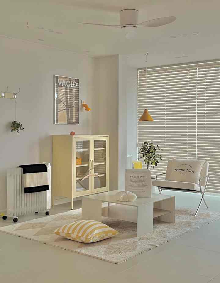 白とベージュの色調のリビング、低いテーブルとクッションが配置されたシンプルで落ち着いた座敷空間