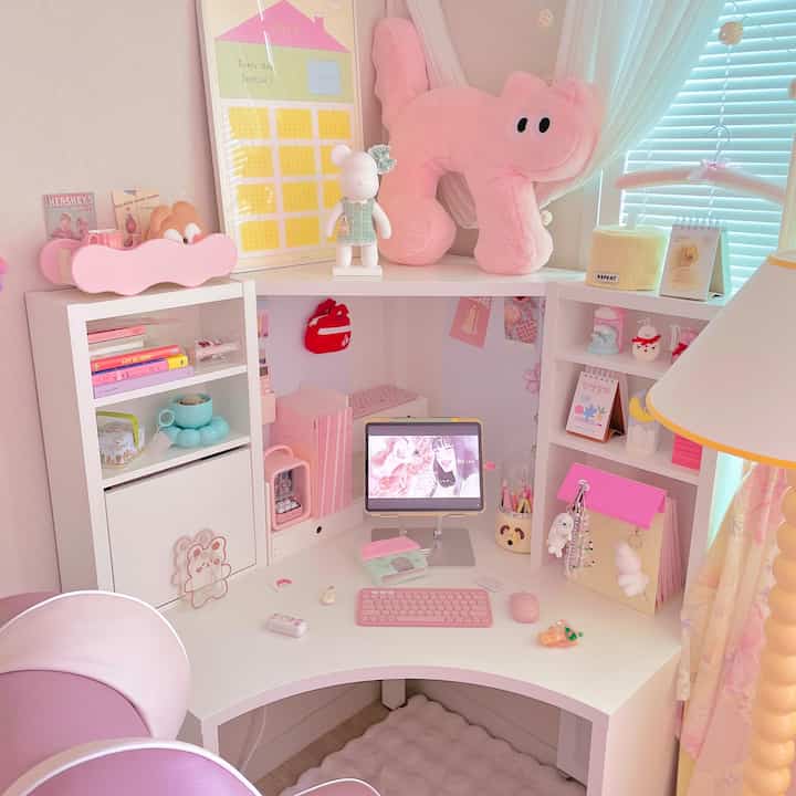 Pastel pink toned corner desk space featuring cute accessories, lighting, and neatly organized playful desk zone