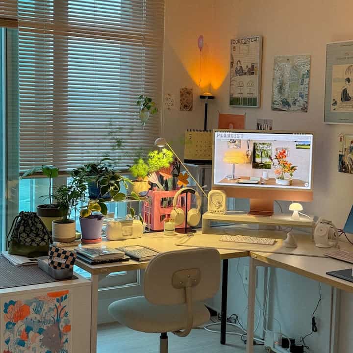 白とナチュラルトーンのホームオフィス、アルミブラインドと多くの植物が配置された雰囲気のある作業空間