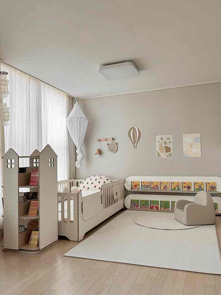 Beige and white toned kids' room featuring a baby crib and toy storage, with a natural and cozy atmosphere