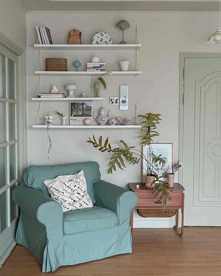 Natural-toned living room featuring a mint armchair and wooden side table with vintage decor for a cozy atmosphere