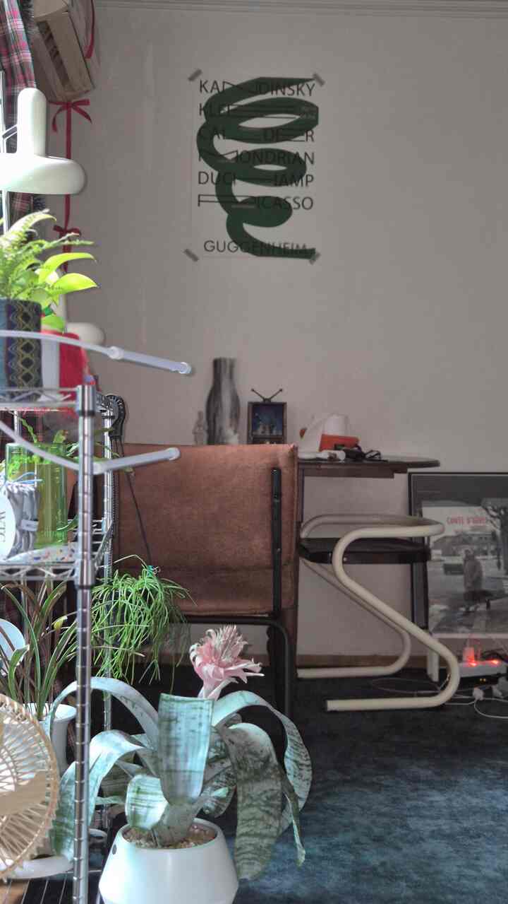 ブラウンとネイビーのトーンが調和するヴィンテージリビング、多様な植物が配置されたナチュラルな雰囲気のインテリア