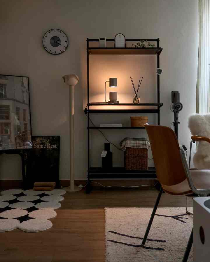 Warm wood tone and black modern living room featuring floor lamp, shelving, and rugs creating a cozy atmosphere