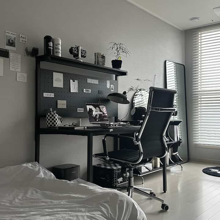 Modern black-toned single household bedroom and home office space featuring a desk and office chair, with a clean and comfortable atmosphere