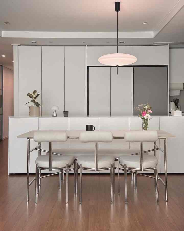 ホワイトとベージュのトーンのキッチン空間、クロイのセラミックダイニングテーブルとテカチェアが配置されたモダンで清潔感のあるインテリア