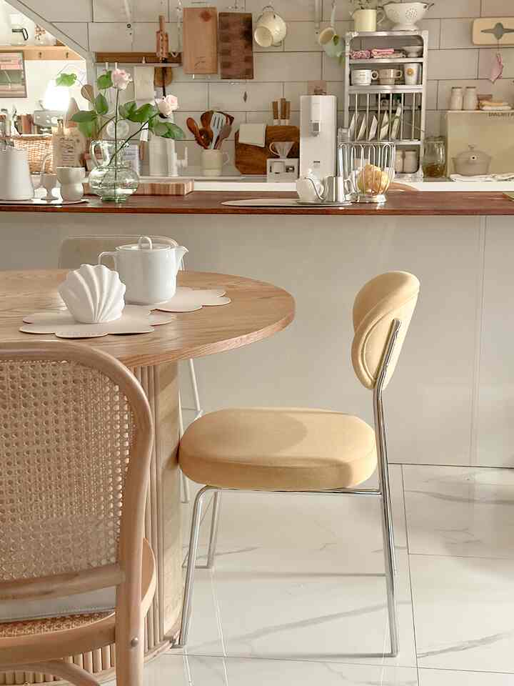 Natural tone kitchen featuring a round dining table and beige dining chairs with cozy atmosphere