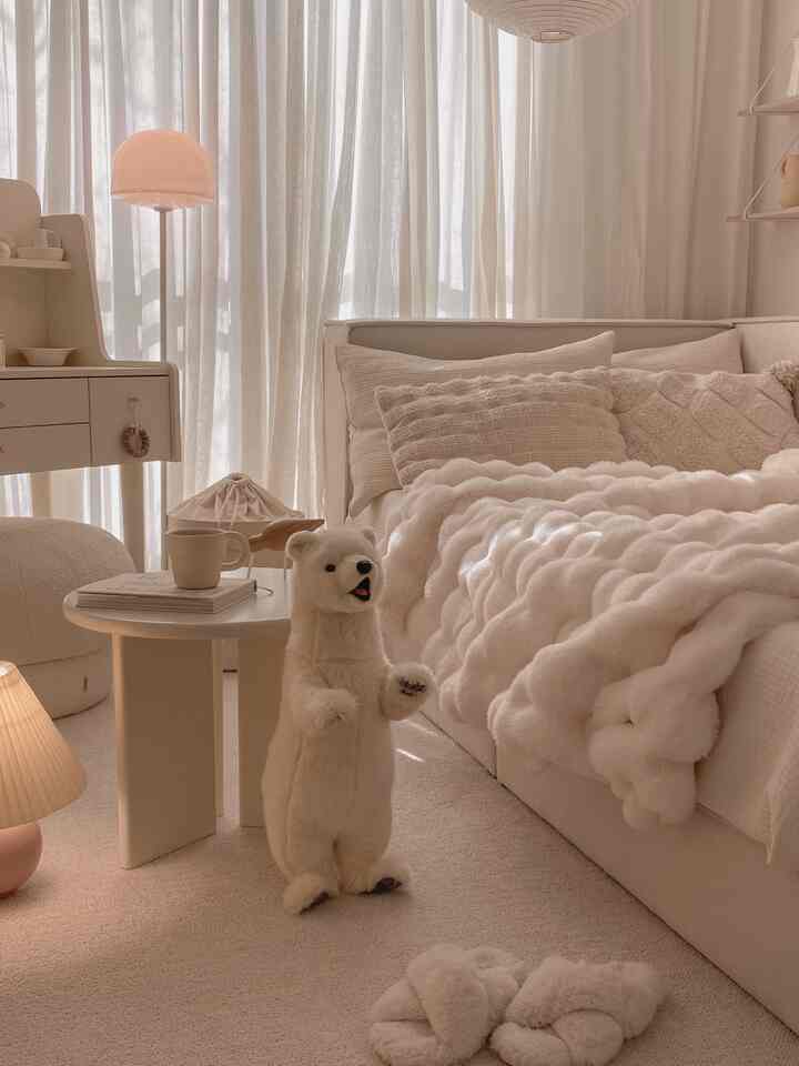Beige and white toned living room featuring cozy cushions, blanket, and a central polar bear plush creating a natural atmosphere