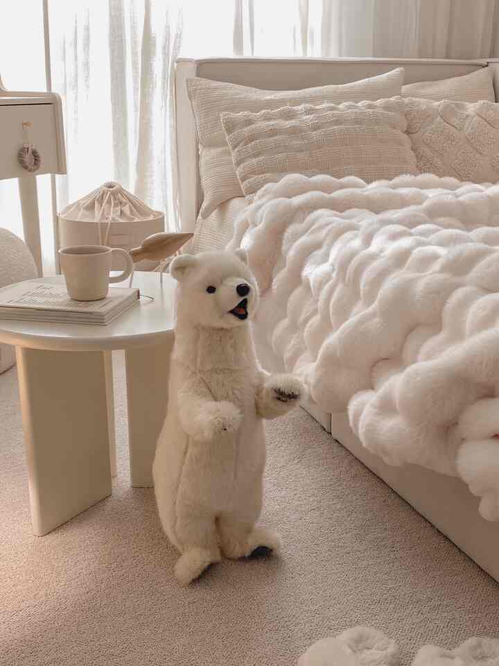 ナチュラルカラーのリビング、ベージュのソファとサイドテーブル、ラグが配置された温かみのある空間