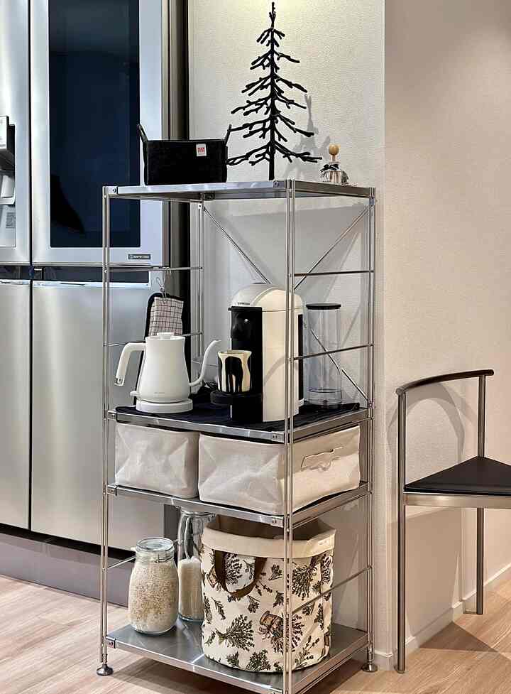 ホワイトとシルバーの色調のキッチンパントリー、スチールシェルフと多様な収納バスケットが整然と配置されたモダンで実用的なおうちカフェスペース