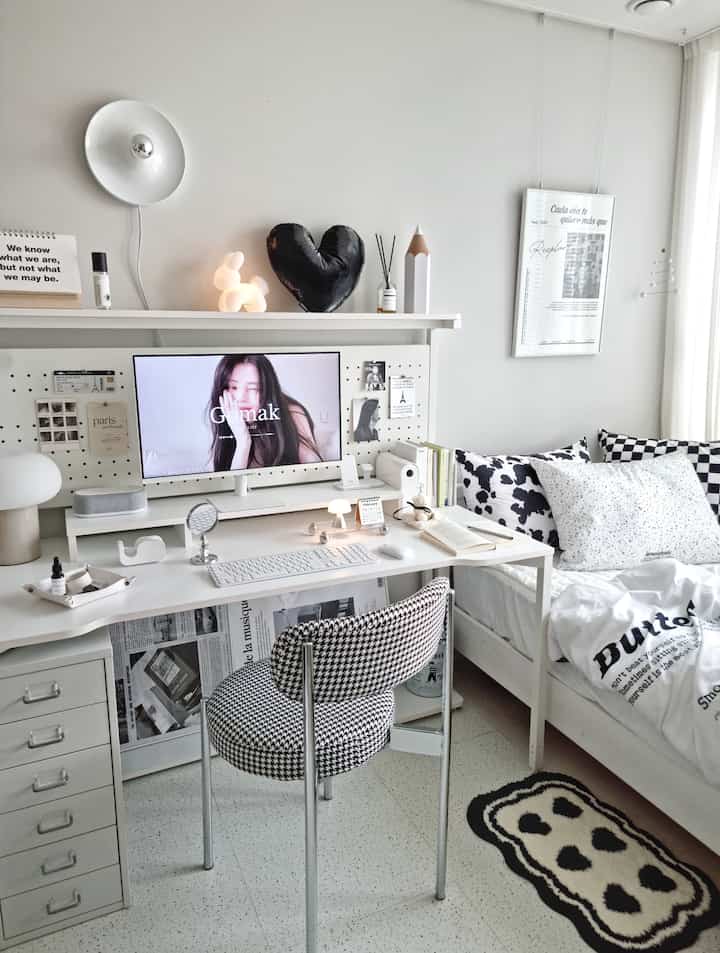 White walls and furniture with black patterned cushions in a kid's room, featuring a modern, clean home office and study setup
