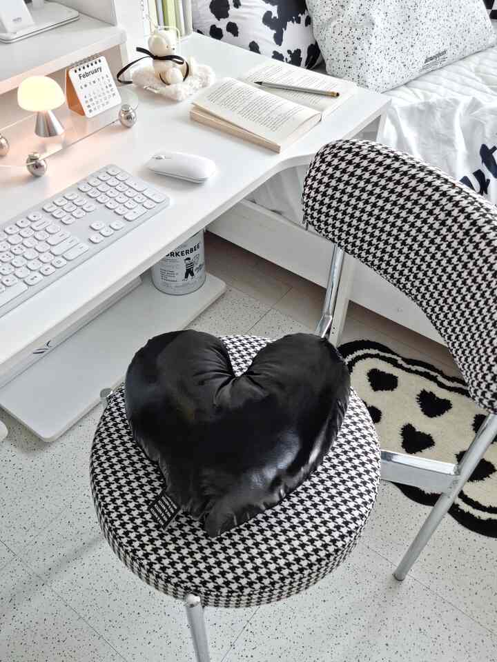 Monochromatic white and black kids' room with desk and houndstooth chair creating a cozy atmosphere