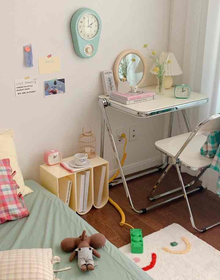 Soft green and white toned small bedroom featuring a simple desk and bed with a natural atmosphere