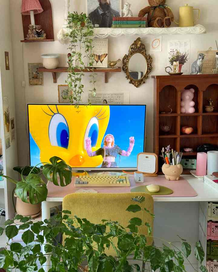 A white and natural toned home office featuring a desk with a monitor and plants, creating a cozy and simple interior