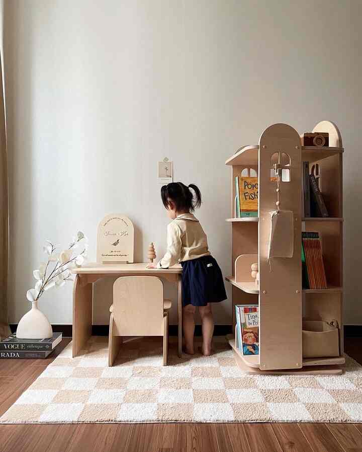 Natural toned kids' room featuring a child desk and rotating bookshelf in a cozy space