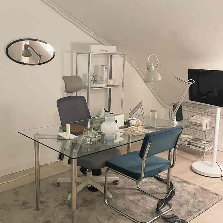 Nordic-style home office featuring a transparent glass table and modern office chair with minimal decor