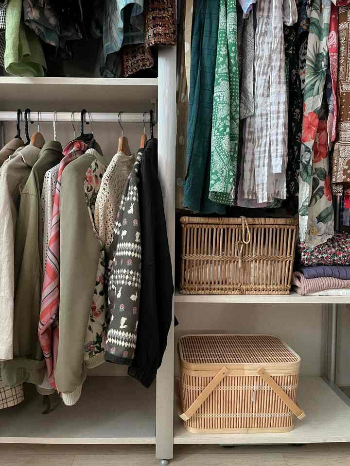 ナチュラルな木目調とホワイトカラーのウォークインクローゼットシステムハンガーと収納が配置された印象的なインテリア