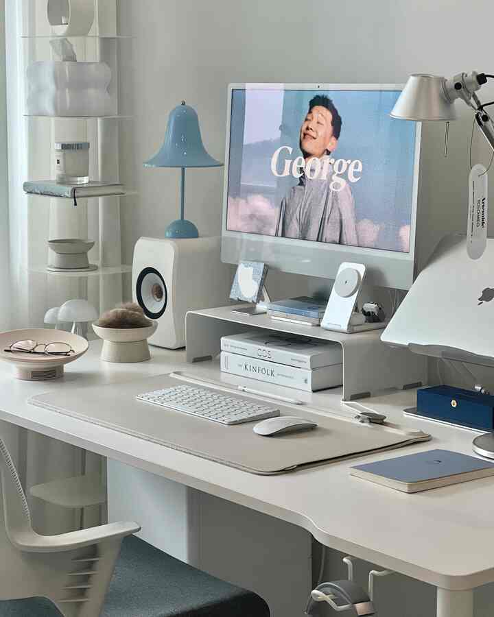 White and gray toned home office featuring a minimalistic modern desk setup with computer, creating a clean workspace atmosphere