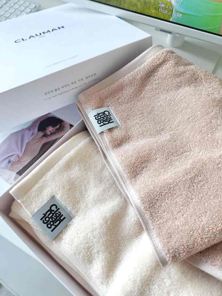 Beige and ivory toned towels neatly placed in a gift box, evoking a luxurious hotel-like atmosphere