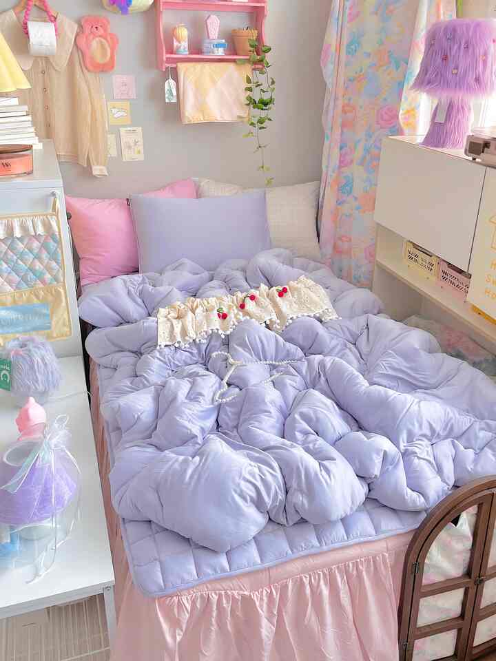 ピンクとラベンダー色調の赤ちゃん用寝室、かわいい装飾と赤ちゃん用寝具が配された雰囲気のある空間