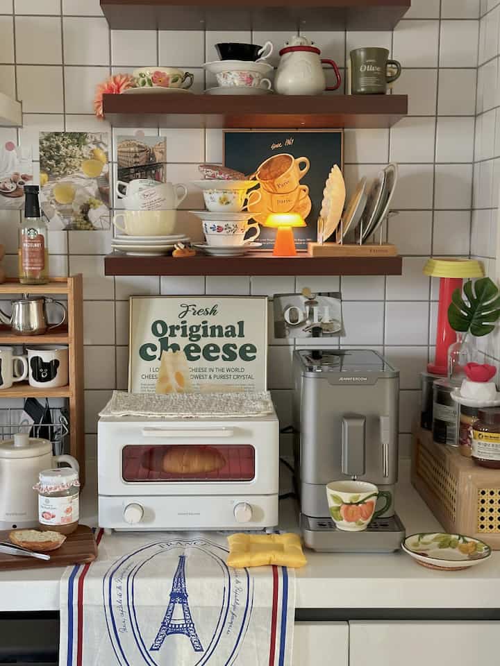 Cozy home cafe kitchen in warm wood tones and white featuring an automatic coffee machine, toaster, and vintage accessories