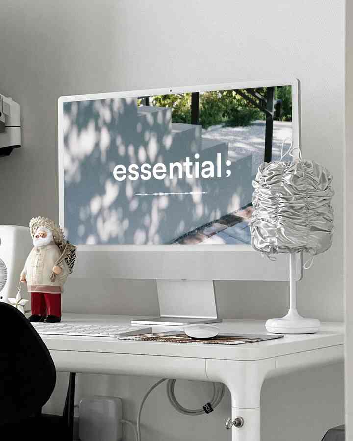 ホワイトとシルバーの組み合わせによるコンパクトなホームオフィス空間、清潔感のあるデスクとアップルのiMacが配置されたモダンな雰囲気のインテリア