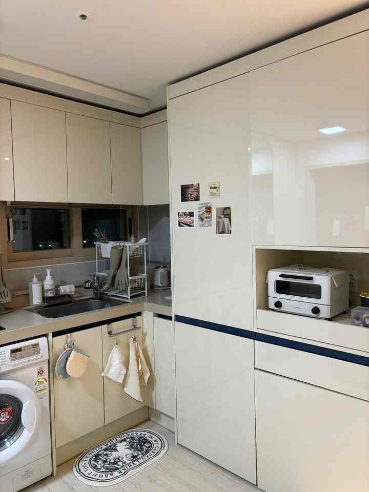 白を基調としたキッチン、カウンターや収納が配置されたコンパクトで清潔感のあるインテリア