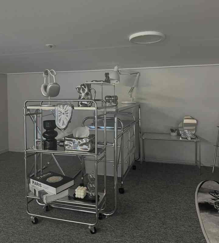 シルバーのクローム素材のモジュラー家具とグレーのカーペットが配置されたミッドセンチュリーモダンのホームオフィス空間