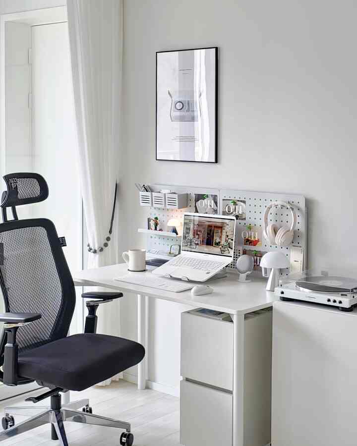 Bright white tone home office space featuring a white desk and black office chair in a clean work environment