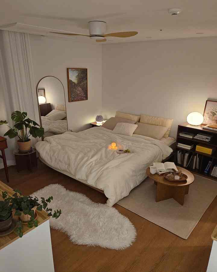 白と木目調が調和したナチュラルモダンな寝室、ナイトテーブルやラグ、植物が落ち着いた雰囲気を演出しているインテリア