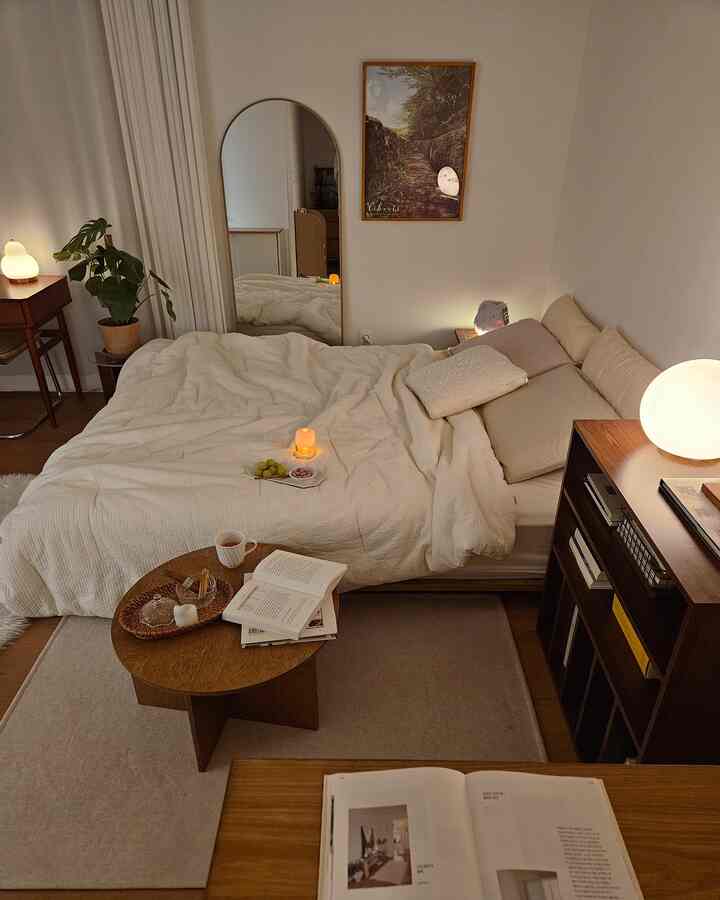 ベージュと木目調の調和した一人暮らし用寝室、ベッドと本棚、温かみのある照明が配置された雰囲気あるインテリア