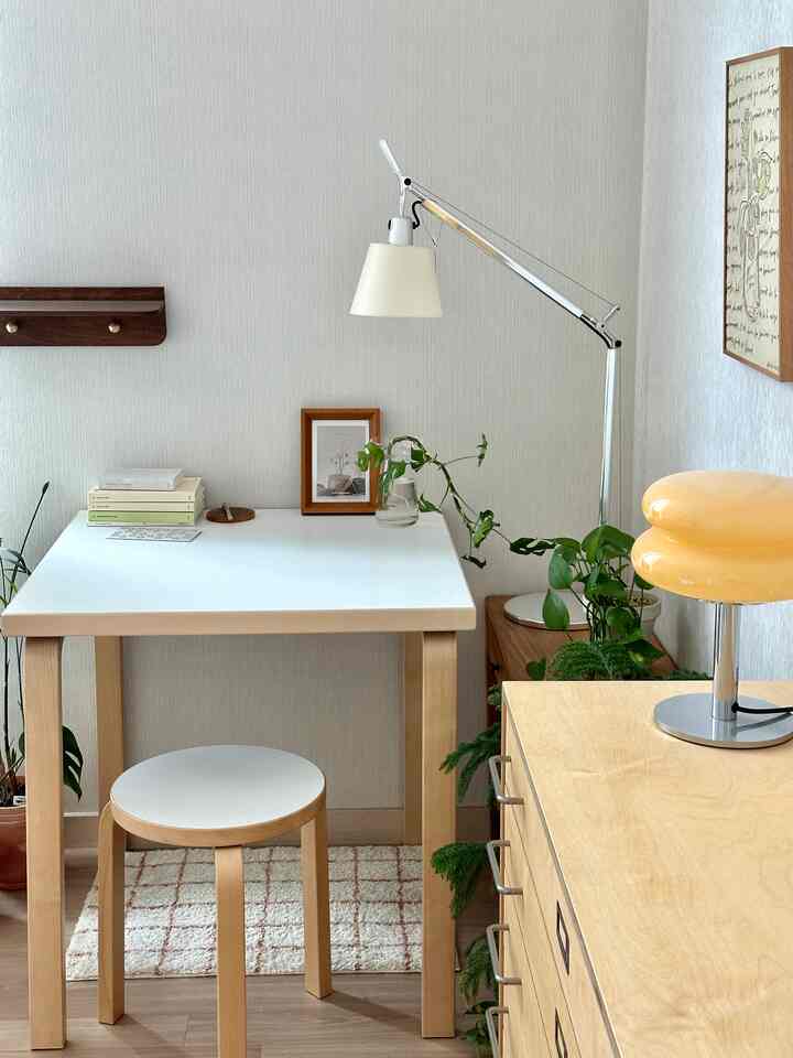 ナチュラルな色調のホームオフィス、木製家具と植物が配置された落ち着いた印象のデスク空間