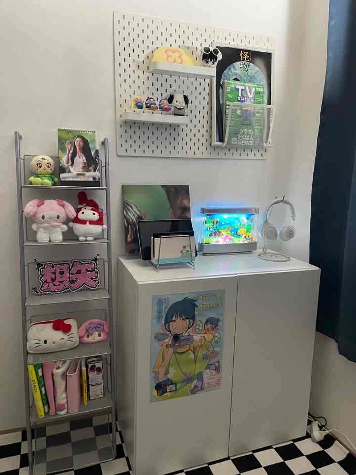 白と黒のトーンが中心のコンパクトな部屋、白い収納家具と金属棚、LEDのフェイク水槽が配置された雰囲気のあるインテリア