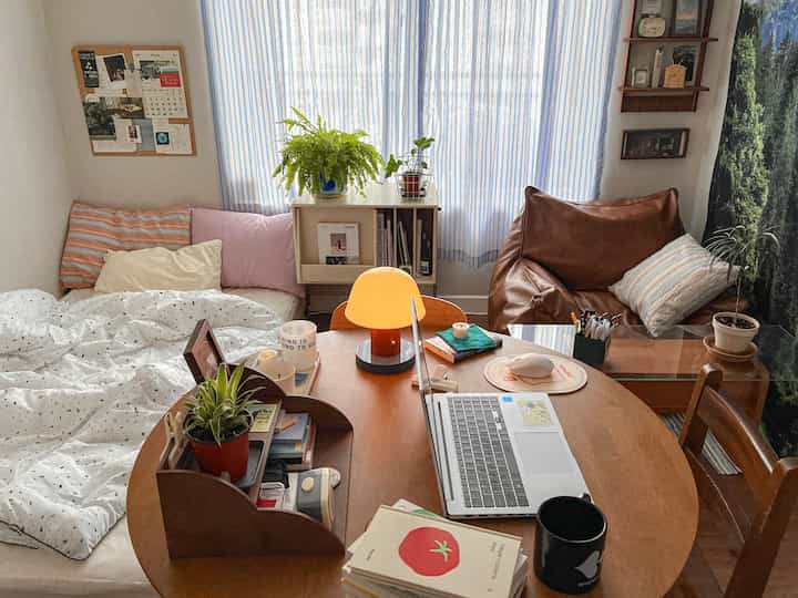 温かな木目調とナチュラルな植物が配置された4坪の寝室兼ワークスペース