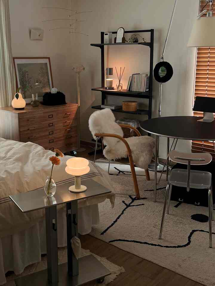 ナチュラルな木目調とモダンな家具が配置されたワンルーム寝室、暖かい照明とラグが調和した居心地の良い空間