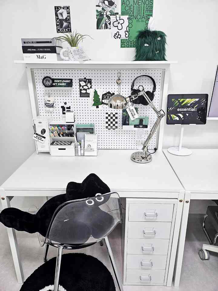 ホワイトとブラック調のホームオフィスデスク、ペグボードと様々な文具が整然と配置されたモダンな空間