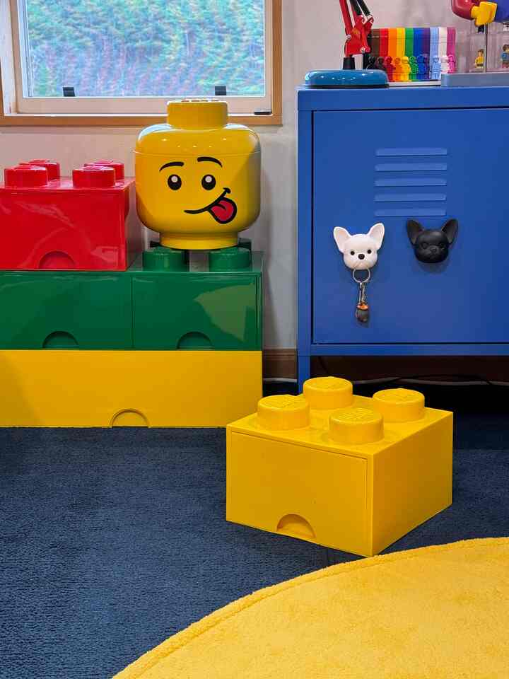 Yellow and blue toned kids' room featuring LEGO drawer organizers and steel storage cabinet in a charming organized space