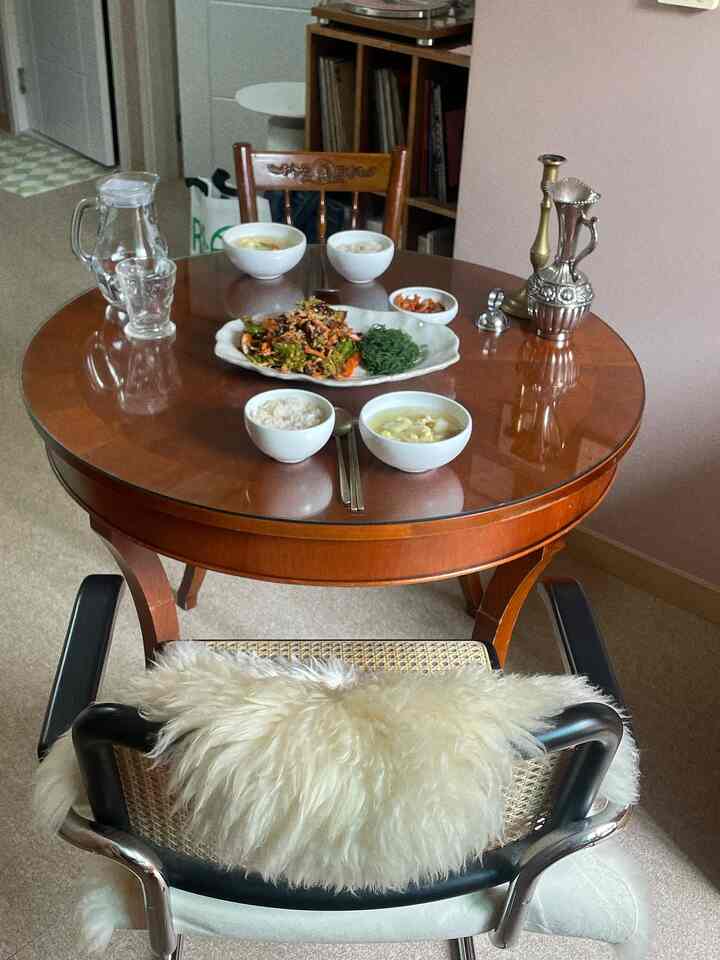 ブラウン調のキッチンダイニングスペース、白い食器に盛られた料理と銀色の装飾品が配置されたナチュラルな雰囲気のインテリア