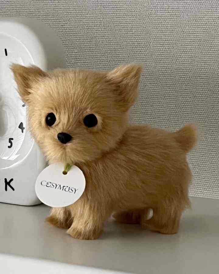 Brown cute dog figurine decor on white surface against textured wall, creating a cozy indoor space