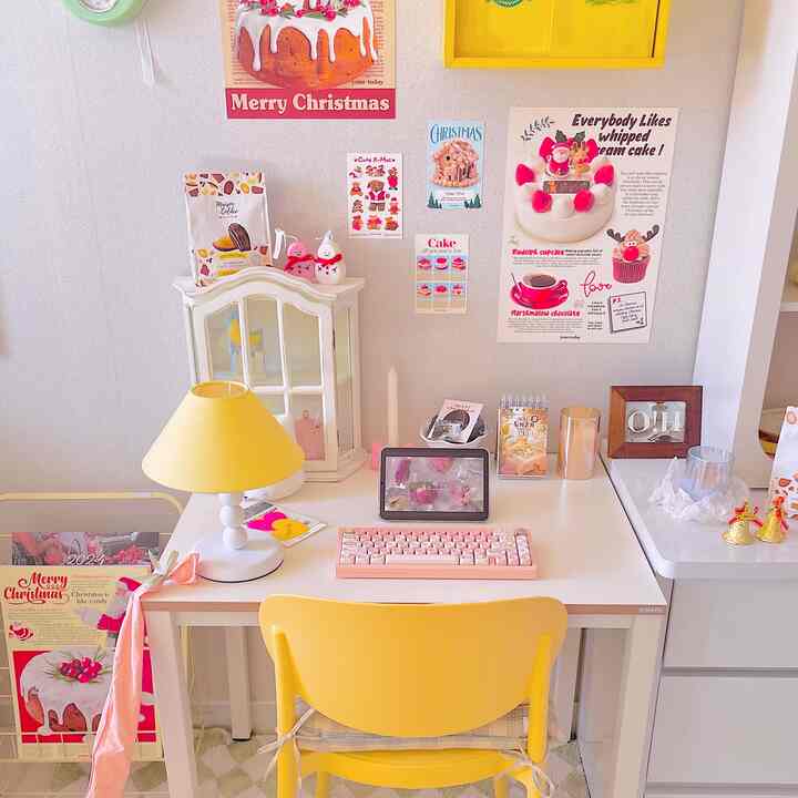 Bright yellow and white toned home office space featuring a clean desk with yellow chair and table lamp, pink keyboard for a cozy workspace