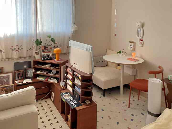 暖かい木目調と白を基調としたワンルーム寝室、モジュール家具で三つの空間に分けられた雰囲気のあるインテリア