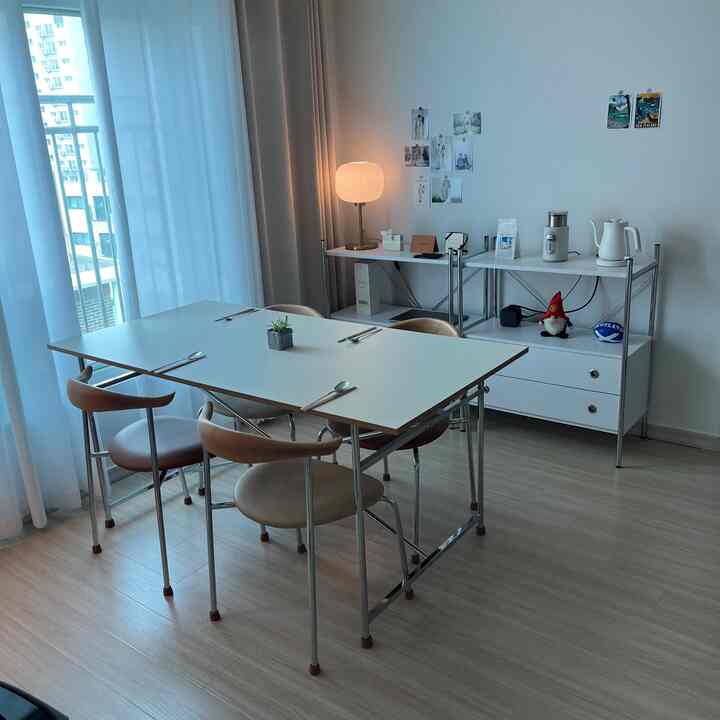 A compact two-person dining room in mid-century modern style featuring white and wood tones with clean layout