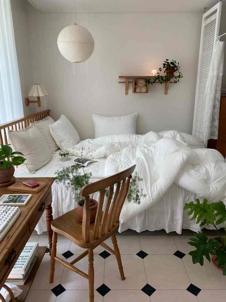 白と木目調が調和した寝室、ナチュラルな木製ベッドフレームと寝具が印象的な空間