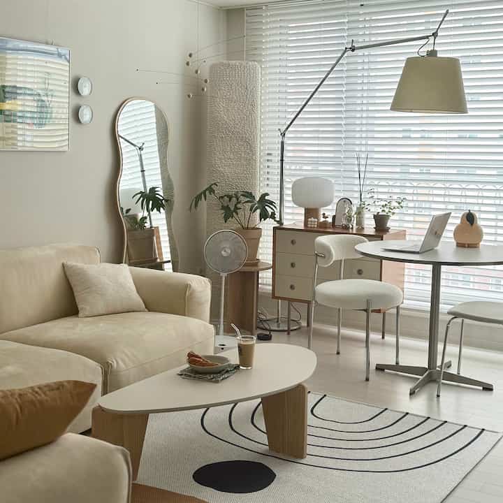 Bright and cozy natural modern living room in beige and wood tones, featuring a comfortable sofa and round tables