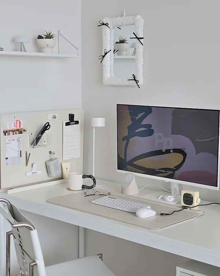 White-toned study space featuring a white desk and monitor with a simple, clean desk interior setup