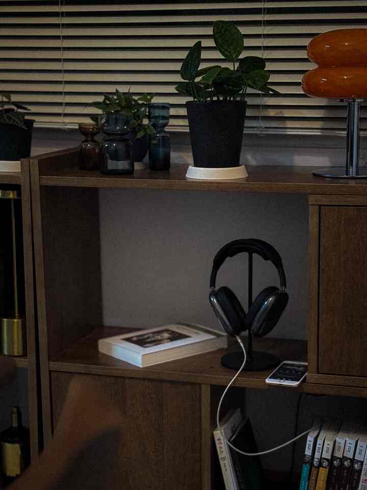 Natural-toned space with brown wood shelves and black headphone stand