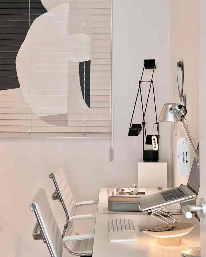 White and silver toned home office space featuring a clean desk and office chairs with a modern atmosphere