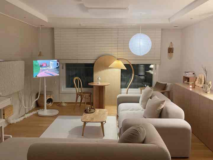 Wood tone and white living room featuring sofa and coffee table with warm, cozy atmosphere