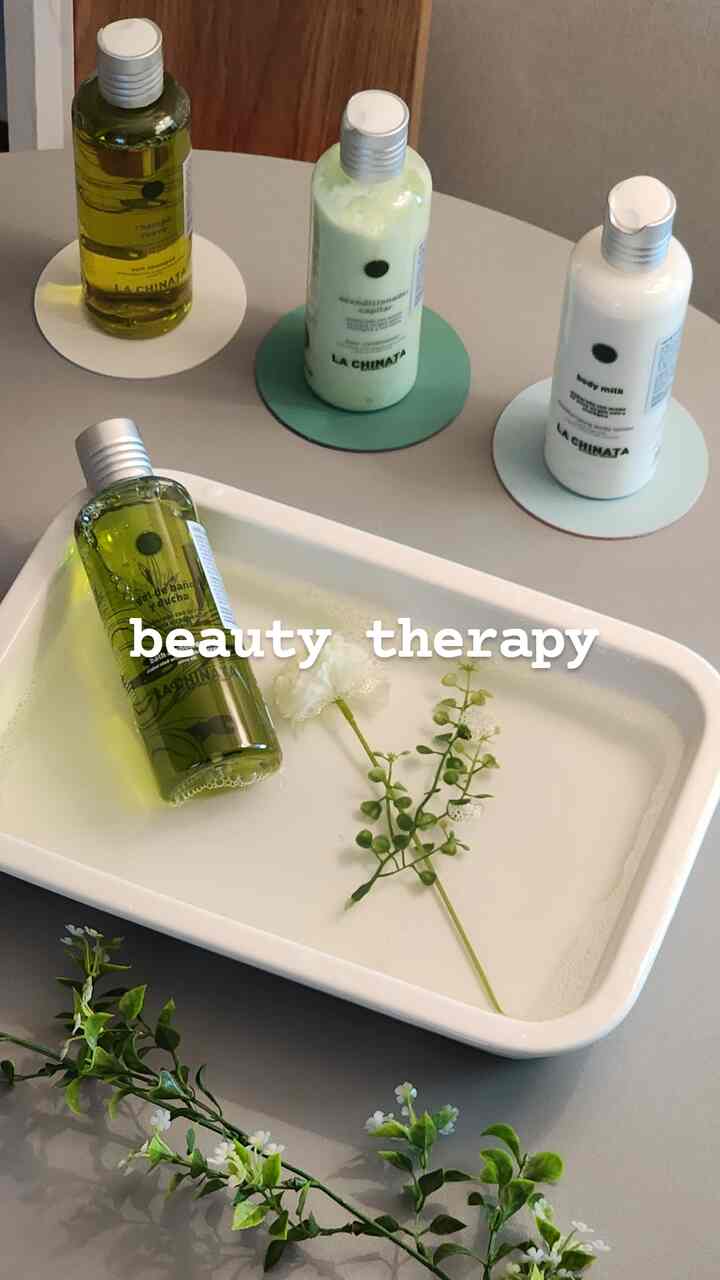 Cafe-style table setup with green and white beauty bottles and diffuser products on a modern dining surface