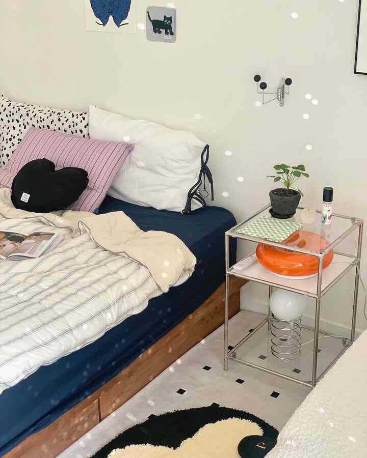 Natural color bedroom featuring a navy mattress and wooden bed with a cozy, simple atmosphere