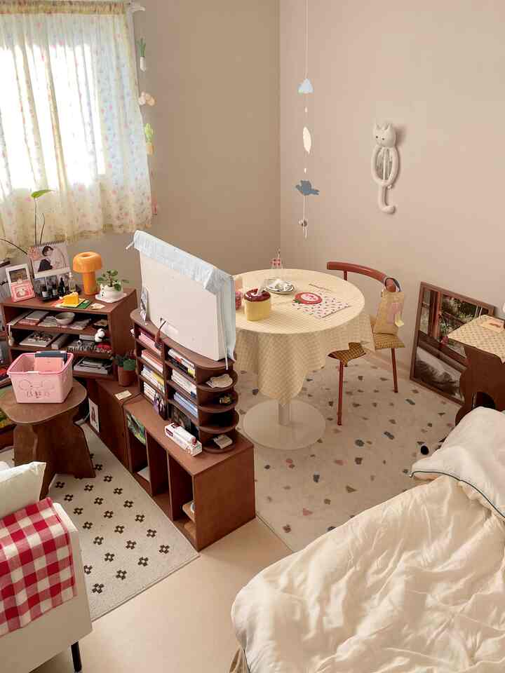 Beige and brown toned small dining and living room featuring cat-themed decor and cozy natural furnishing